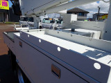 アイチ製 SB10A 9.7M 2703h 最大バケット積載荷重200kg FRP製バケット/首振り/作業灯1個 右リア100Vコンセント用電源ケーブル付 左リア地上アースコード付 上物左右工具棚&右側はしご掛