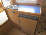 キッチンスペースはシンク・90L冷蔵庫、棚上には電子レンジがございます。隣接する一人掛け
