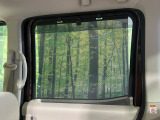 【ロールシェード】日差しや車外からの光が眩しいときにサッと引き出して使える、ロール格納タイプのサンシェードを装備。後席に乗ったお子様がウトウトしだした時など、ぜひご活用ください♪