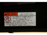 バックドアの底部にイージークローザーの注意書きステッカーが貼られています。