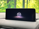 【10.25インチマツダコネクト】車内の雰囲気にマッチした大型ディスプレイ。スマホ接続でのナビ使用やBluetooth再生等、様々な機能が楽しめます。直感的なダイヤル操作が可能で、使い勝手も良好です。