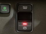 セレクトレバーの右に電子制御パーキングブレーキがあります。スイッチひとつで、停車した地点の傾斜などをシステムが検知・判断してブレーキ力を自動的に最適制御し、しっかり停車できるパーキングシステムです。
