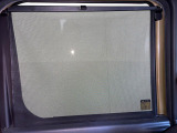 【ロールシェード】日差しや車外からの光が眩しいときにサッと引き出して使える、ロール格納タイプのサンシェードを装備。後席に乗ったお子様がウトウトしだした時など、ぜひご活用ください♪