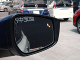 後側方から接近する車を検知してドアミラー内に表示、さらに衝突の危険度が高まるとシステムが車線内に戻す方向に力を短時間発生させ、ドライバーがクルマを車線内に戻す操作を促します。