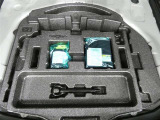 パンク修理剤とエアーポンプのセットです。スペアタイヤは装備していませんが空いたスペースを小物入れとして使用できます