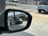 後側方から接近する車を検知してドアミラー内に表示、さらに衝突の危険度が高まるとシステムが車線内に戻す方向に力を短時間発生させ、ドライバーがクルマを車線内に戻す操作を促します。