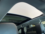 【電動パノラミックルーフ】車内に気持ちいい自然光が差し込み、頭上に広がる風景をお楽しみいただけます。快適な車内温度を維持し日差しから乗員とインテリアを守るダークカラーのガラス。電動ブラインド付き!