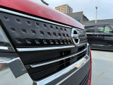 日産車の共通意匠であるVモーショングリルを採用し、大型のメッキバーがヘッドランプへと連続して一体感を強調するデザインです。