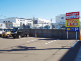 店舗入口向かい側に広いお客様駐車場があります。赤と黄色の看板が目印です。