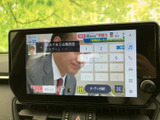 テレビの番組画面を表示でき、停車中の待ち時間に映像を楽しめます。画面上にはチャンネル選択やオーディオ関連の表示もあり、停車時に見たい番組を選びやすい仕様です。