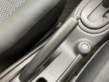 前席の間にパーキングブレーキを配置し、運転席から手の届きやすい位置に設けています。周囲はすっきりとまとまり、シフトレバー近くで操作部を確認しやすいレイアウトです。