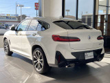 X4らしいクーペスタイルを象徴するリアビュー。ワイドなボディと横方向へ広がるテールランプが、安定感のあるスタンスを演出します。