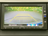 後方の様子を画面で確認しながら駐車でき、黄色のガイドラインが車庫入れの目安になります。周囲を直接確認する案内も表示され、駐車時の安全確認をサポートする便利な装備です。