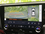 後方の映像と車両周囲を見下ろす表示を切り替えて確認でき、駐車時の周囲確認を助けます。ガイド線も画面に表示されるため、駐車スペースに車を入れる際の目安として活用できます。