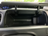 開閉できる収納スペースが設けられ、車内で小物をまとめておく際に便利です。手の届きやすい位置にあり、日常の移動中に必要な品を整理しておける実用的な設計です。