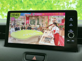 画面いっぱいにテレビ番組が表示され、停車中に映像を楽しめます。画面脇にはホームや戻るボタン、音量調整用のダイヤルも備わり、停車時のひとときに便利にご活用いただけます。