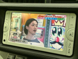 ナビ画面にはテレビ番組が表示され、停車中の休憩時間に映像を楽しめます。画面の周囲には音量調整などのボタンがまとまっており、停車中でも操作場所を把握しやすい配置です。