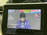 画面にテレビ番組が表示され、停車中の待ち時間に映像を視聴できます。画面上には時刻も表示されており、車内で過ごす時間を有効に使える装備です。