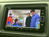 画面には映像が表示され、時刻もあわせて確認できます。画面まわりにはメニューやオーディオのボタンが配置されており、停車中に使いたい項目へアクセスしやすい設計です。
