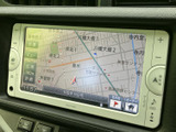 画面には周辺の地図が表示され、現在地や道路の位置関係を確認できます。画面脇には音量や表示切替などのボタンを配置し、案内を確認したいときにも扱いやすいナビゲーションです。