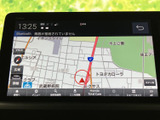 地図上に現在地や道路、周辺の施設が表示され、目的地までの位置関係を確認しやすい画面です。縮尺や案内などの操作項目も見やすく配置されており、行き先を調べる際にも使いやすいナビゲーションです。