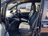 前席からフロントガラス越しに前方を見渡しやすく、運転席と助手席の間もゆとりある配置です。座面や背もたれに落ち着いた色合いを用い、くつろぎやすい空間です。