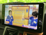 画面には番組映像が表示され、停車中に映像やテレビを視聴する際に活用できます。大きく見やすい表示で、タッチ操作部も画面脇に配置されており、停車時に扱いやすい装備です。
