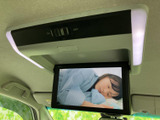 天井に設置されたモニターで、停車中に映像やテレビを楽しめます。頭上から画面を確認できるため、休憩時間のお供にも便利。使用しない時は折りたたんで収納できます。