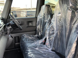前席は運転席と助手席が並び、車内の様子を見渡しやすいレイアウトです。窓から明るさが入り、シートにはカバーが掛けられています。