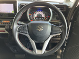 ステアリングの左右にスイッチが備わり、運転姿勢を保ちながら手元で各種機能を扱いやすい配置です。握る部分の赤いステッチも、室内のアクセントになっています。