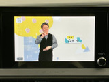 画面には映像が表示され、中央の操作部から音量調整などを行える構成です。停車中のエンターテインメントにも活用でき、車内で過ごす時間をより便利にする装備としてご案内いたします。