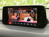 テレビ番組の映像と番組情報が画面に表示され、停車中に映像やテレビを視聴して過ごせます。画面下部には操作メニューも並び、必要な項目を確認しやすい構成です。