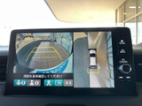 後方の映像に加えて車両周囲を上から見た表示も確認でき、駐車時の周囲確認をサポートします。画面上のガイド表示もあり、狭い場所での取り回しに役立つ装備です。
