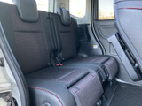 後席は左右に並ぶシートとヘッドレストで、同乗者がゆったり過ごせる空間です。窓から外の様子を確認しやすく、シート中央の仕切りや足元のスペースも備えた、落ち着いた車内です。