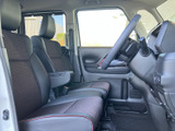 前席は窓から光が入り、運転席と助手席の見通しもすっきりとしています。シートには落ち着いた色合いの表皮と赤いアクセントが添えられ、アームレストも備わるくつろぎの空間です。