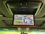 後席向けのモニターを備え、停車中に映像を楽しめるほか、同乗者が過ごす時間を快適に演出します。天井部に設置され、車内での移動時間を便利に活用できる装備です。