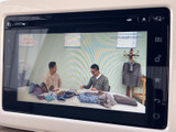 画面にはテレビ番組が表示され、停車中に映像やテレビを視聴できます。メニュー画面から切り替えられるため、休憩時間などに車内で過ごす際にも活用いただけます。