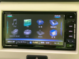 画面には目的地や音楽、テレビなどのメニューが表示され、項目を見比べながら選べる構成です。周囲には用途ごとのボタンが並び、画面表示と合わせて操作箇所を確認しやすくなっています。