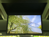 天井に備わるモニターは、画面を大きく展開して映像を楽しめる装備です。使わないときは収納でき、車内で映像を見る時間を過ごしたいときに活用いただけます。