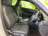 前席は体を支える形状で、運転席と助手席の間にはアームレストや収納スペースも備わります。乗り降りしやすい開口部から、落ち着いた室内の様子を確認できます。
