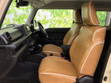 前席はブラウン系のシートに白い縁取りを合わせ、車内にあたたかな印象を添えています。背もたれと座面には縦のステッチが入り、前席それぞれに肘掛けも備わる構成です。