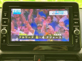 テレビ番組を表示できるモニターを備え、停車中の待ち時間に映像を楽しめます。画面には番組映像が表示され、車内で過ごす時間の過ごし方が広がる便利な装備です。