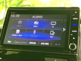 画面にはオーディオやテレビ、電話などのメニューが並び、目的の項目を見つけやすい表示です。画面横にも操作ボタンが配置され、移動中の案内や音楽再生など日常のドライブに活用できます。