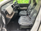 前席まわりは視界が開け、運転席から前方を見渡しやすいレイアウトです。左右のシートは明るい色合いでまとめられ、足元にもゆとりが感じられる、すっきりとした室内空間です。