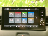 画面にはナビや電話、ラジオなどの項目が並び、目的に応じて選びやすい構成です。ホームや戻る、音量の操作部も備わり、日常の移動中に使いたい機能へアクセスできます。