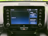 大きな画面にホーム情報が表示され、オーディオの状態や車両情報などをひと目で確認できます。周囲には主要メニューのボタンと音量調整部がまとまり、画面の切り替えや日常の操作も分かりやすい配置です。