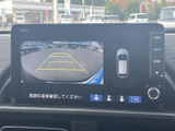 後方の映像と車両周辺の表示を画面で確認でき、駐車時の周囲確認をサポートします。ガイド線も表示されるため、車庫入れや駐車位置を合わせる際に役立つ装備です。