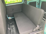 後席は横並びのベンチタイプで、窓から明るさを取り込む車内空間です。座面と背もたれが一体感のある形状で、乗員が落ち着いて過ごせるシンプルな室内に仕上がっています。