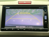 画面には車両後方の映像と目安線が表示され、駐車時に後ろの状況を確認する際に役立ちます。周囲を直接確認しながら、車庫入れや切り返しをサポートします。