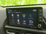 ラジオやテレビ、スマートフォン連携など複数のメニューを画面上で選べます。物理ボタンとダイヤルも備わり、音楽や情報の利用時に操作しやすい配置です。